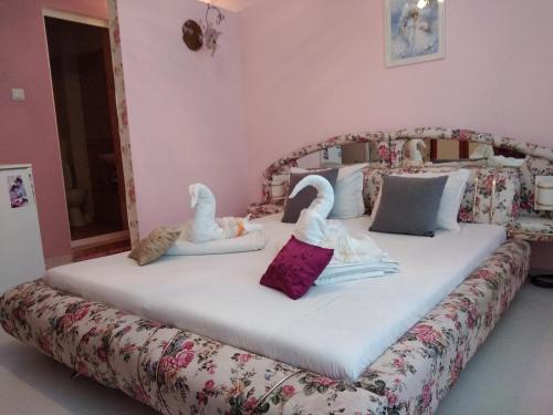 two swans on a bed in a room at Къща за гости Синьо Лято in Pomorie