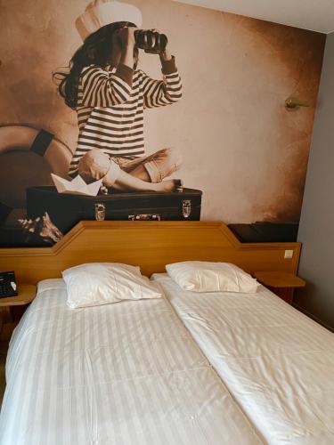 a woman taking a picture of a bed at Liberty in Blankenberge