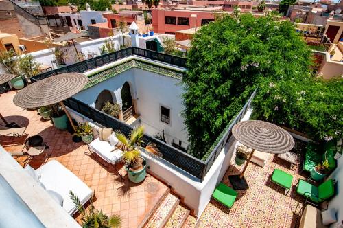 an aerial view of a building with patio furniture and umbrellas at Hotel & Spa Riad Dar El Aila in Marrakech
