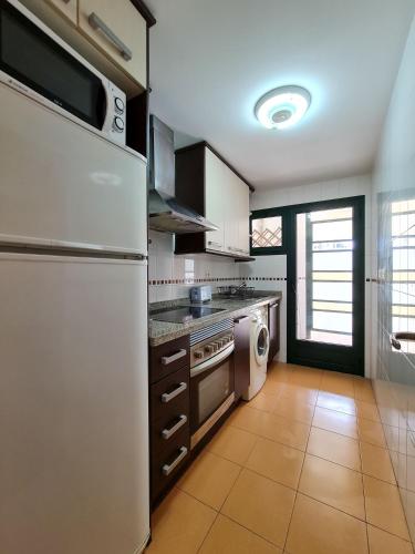 a kitchen with a refrigerator and a dishwasher at Apartamento Completo Torresol I in Benidorm