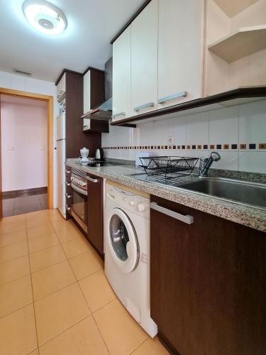 a kitchen with a washing machine and a sink at Apartamento Completo Torresol I in Benidorm