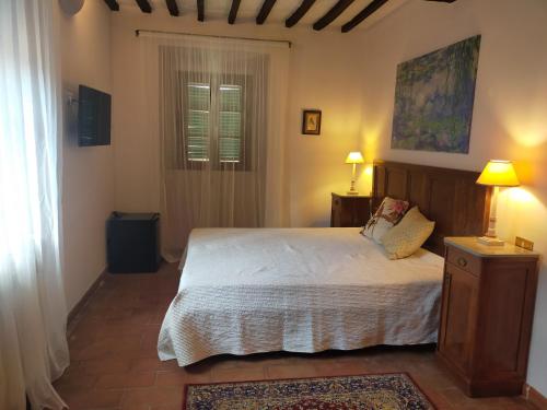 a bedroom with a bed and two lamps and a window at Tenuta Mocajo in Guardistallo