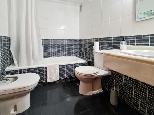 a bathroom with a toilet and a tub and a sink at Apartamento Completo Torresol I in Benidorm