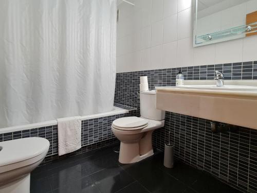 a bathroom with a toilet and a sink and a tub at Apartamento Completo Torresol I in Benidorm