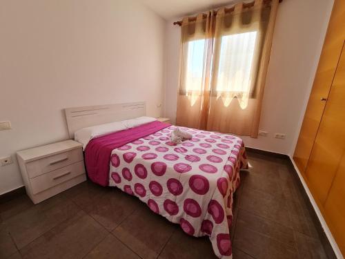 a bedroom with a bed with a cat sitting on it at Apartamento Completo Torresol I in Benidorm