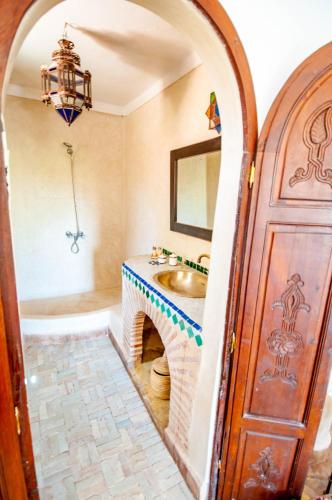 a bathroom with a sink and a mirror at Hotel & Spa Riad Dar El Aila in Marrakech