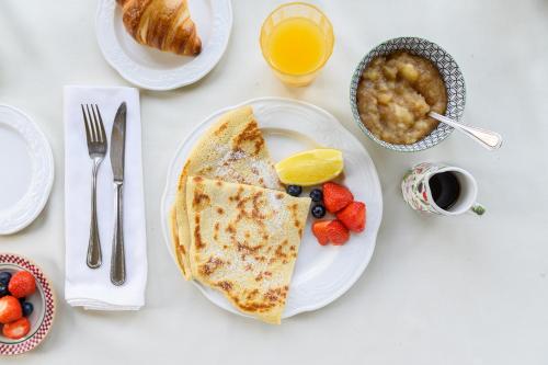 a table with a plate of food with pancakes and fruit at Killarney Lodge in Killarney