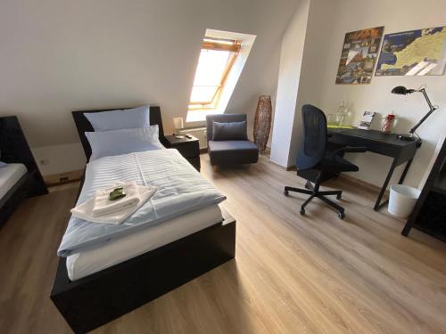 a bedroom with a bed and a desk and a chair at Ferienwohnung Am Jacobsweg in Wurzen