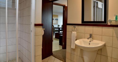 y baño con lavabo y espejo. en ANEW Hotel Ocean Reef Zinkwazi, en Zinkwazi Beach