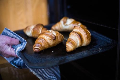 a person holding a plate with croissants on it at Killarney Lodge in Killarney