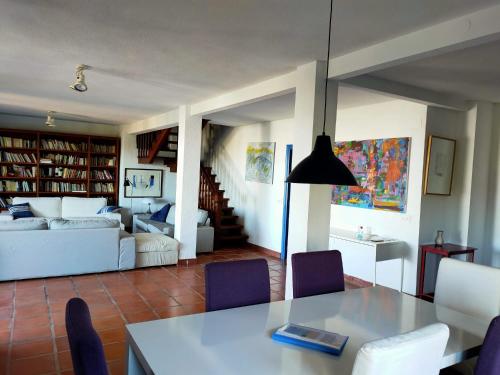 ein Wohnzimmer mit einem Tisch, Stühlen und einem Sofa in der Unterkunft Auténtica Casa Mediterránea con vistas al mar in Santa Pola