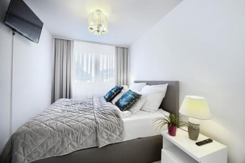 um quarto branco com uma cama e uma janela em Apartament Clipper em Mielno