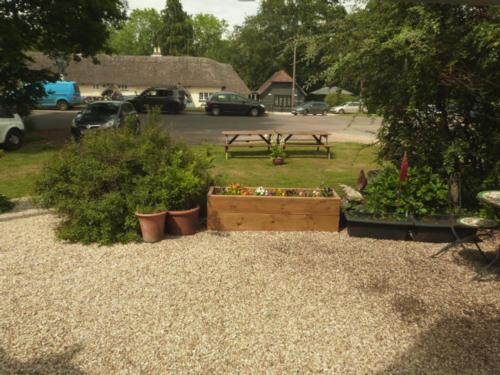 a garden with potted plants and a picnic table at Twin Oaks Guest House in Cadnam