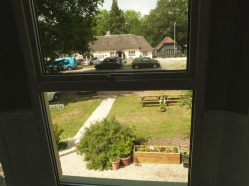 a window with a view of a yard with a park at Twin Oaks Guest House in Cadnam