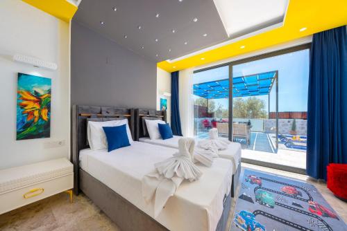 zwei Betten in einem Zimmer mit großem Fenster in der Unterkunft Çınar 1-2 - 2 Bedroom with jacuzzi in Kalkan in Kaş