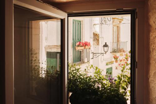 a window view of a balcony with flowers at 1783 Dimora d'Epoca in Locorotondo