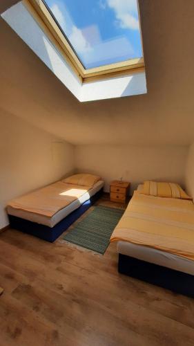 2 Betten in einem Zimmer mit Dachfenster in der Unterkunft Schönermarker Pferdeparadies in Niederlandin