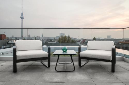two chairs and a table on a balcony with a view at AMANO HOME Apartments in Berlin