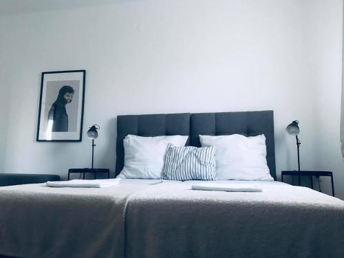 a bedroom with a large bed with white sheets at Galéria Panzió in Nagykanizsa