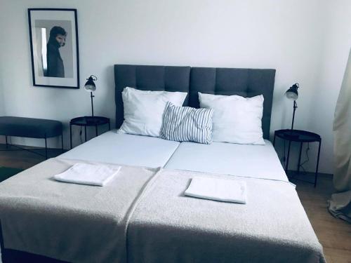 a bedroom with a large bed with two towels on it at Galéria Panzió in Nagykanizsa