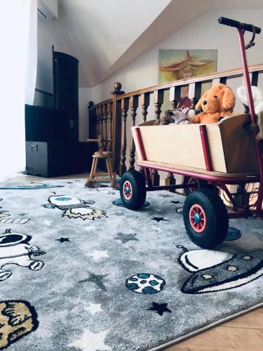 a wheelbarrow with stuffed animals in it in a room at Galéria Panzió in Nagykanizsa