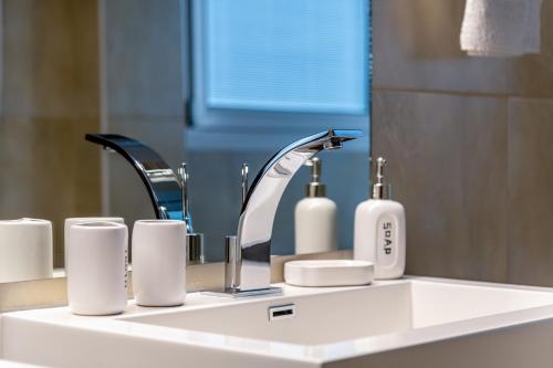 a bathroom sink with a faucet and cups on it at Villa Miniera in Linopótis
