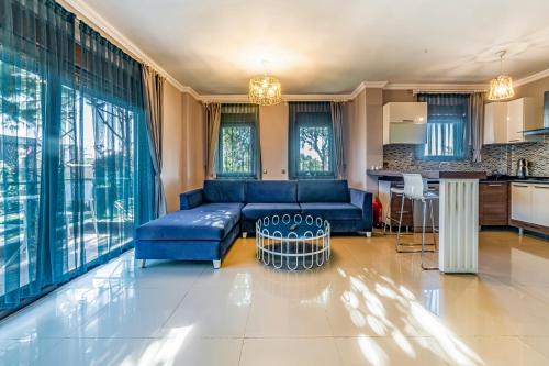 a living room with a blue couch and a kitchen at VISTA Villa in Belek
