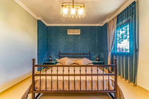 a bedroom with a bed with blue walls and a chandelier at VISTA Villa in Belek