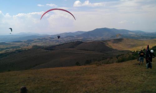 a group of people flying kites on a hill at Villa Ducic in Zlatibor