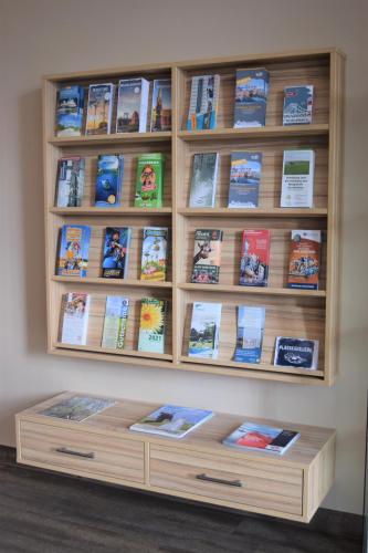 a book shelf filled with lots of books at Nordseehotel Wilhelmshaven in Wilhelmshaven