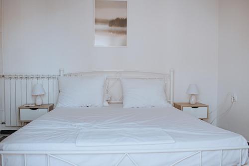 a white bed with white sheets and pillows at Ether Seaside Apartment 1 in Samos