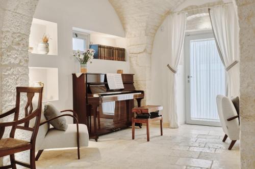 a living room with a piano and a chair at 1783 Dimora d'Epoca in Locorotondo