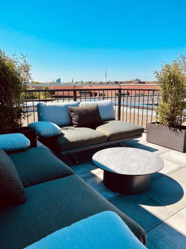 a patio with a couch and a coffee table at hood house in Hamburg
