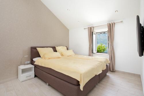 ein Schlafzimmer mit großem Bett und Fenster in der Unterkunft Apartments D&V in Kotor