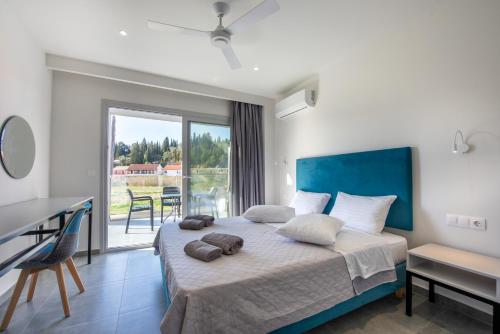 sypialnia z łóżkiem i dużym oknem w obiekcie Anemona Beach apartments w Sidari
