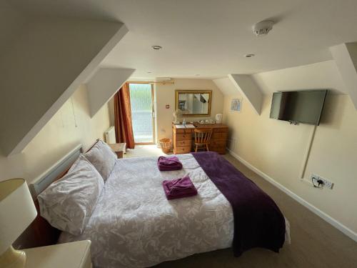 a bedroom with a bed with purple towels on it at Station House, Dartmoor and Coast located, Village centre Hotel in South Brent
