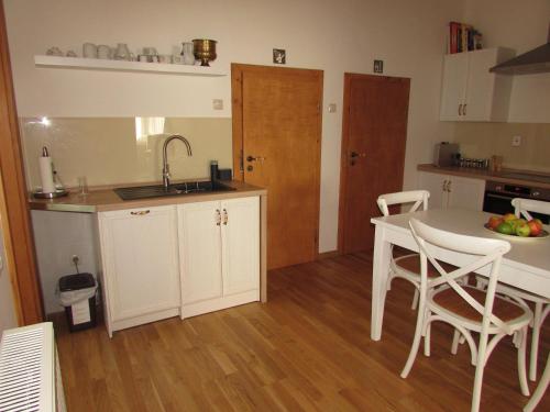 a kitchen with a table and chairs and a sink at Bara ház in Tvrdošovce