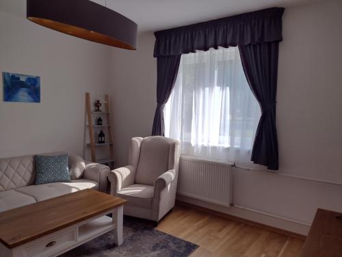 a living room with a couch and chairs and a window at Bara ház in Tvrdošovce