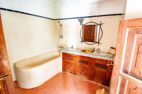 a bathroom with a tub and a sink at Hotel & Spa Riad Dar El Aila in Marrakech