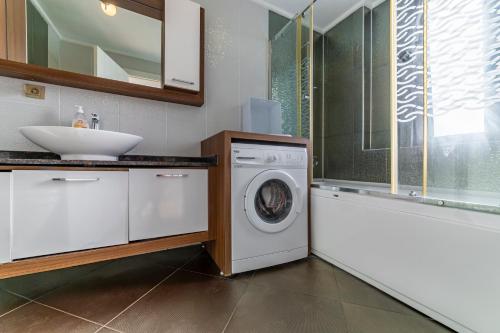 a bathroom with a washing machine and a sink at VISTA Villa in Belek