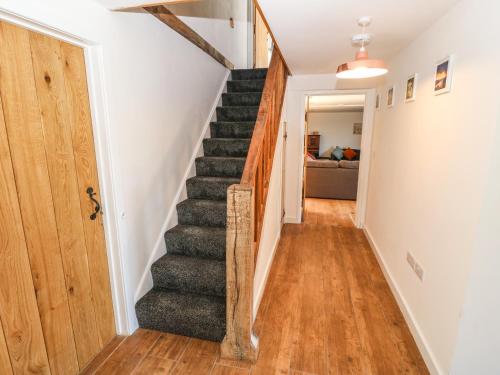a stairway in a home with white walls and wooden floors at Bwthyn Y Bugail Shepherd's Cottage in Oswestry