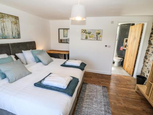 two beds in a small room with a bathroom at Bwthyn Y Bugail Shepherd's Cottage in Oswestry