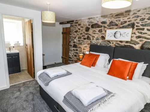 a bedroom with a large bed with orange pillows at Bwthyn Y Bugail Shepherd's Cottage in Oswestry