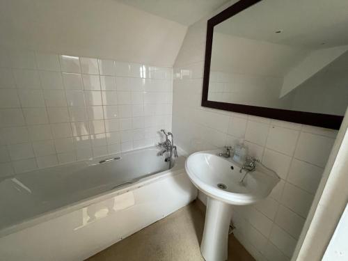 a bathroom with a sink and a tub and a mirror at Station House, Dartmoor and Coast located, Village centre Hotel in South Brent