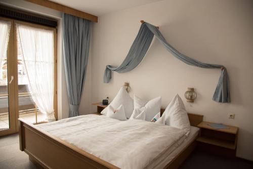 a bedroom with a large bed with white sheets and pillows at Haus Feichtner in Reit im Winkl