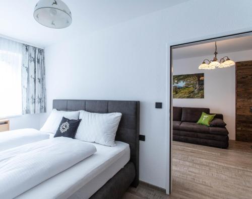 a bedroom with a white bed and a mirror at Apartment Tauernfex Kaprun in Kaprun