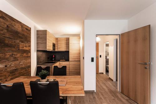 kuchnia i jadalnia z drewnianym stołem i krzesłami w obiekcie Apartment Tauernfex Kaprun w Kaprunie
