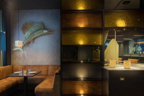 a restaurant with a couch and a table and a fish on the wall at Hotel ZOE by AMANO in Berlin