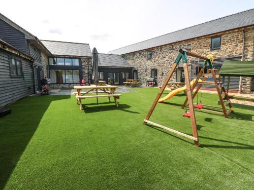 a playground with a swing set and a picnic table at Y Beudy The Dairy in Oswestry