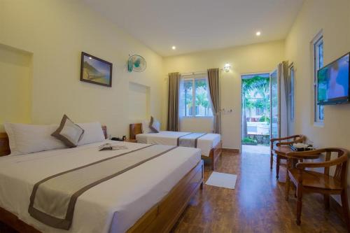 a hotel room with two beds and a television at Blue Paradise Bungalow Phu Quoc in Phu Quoc